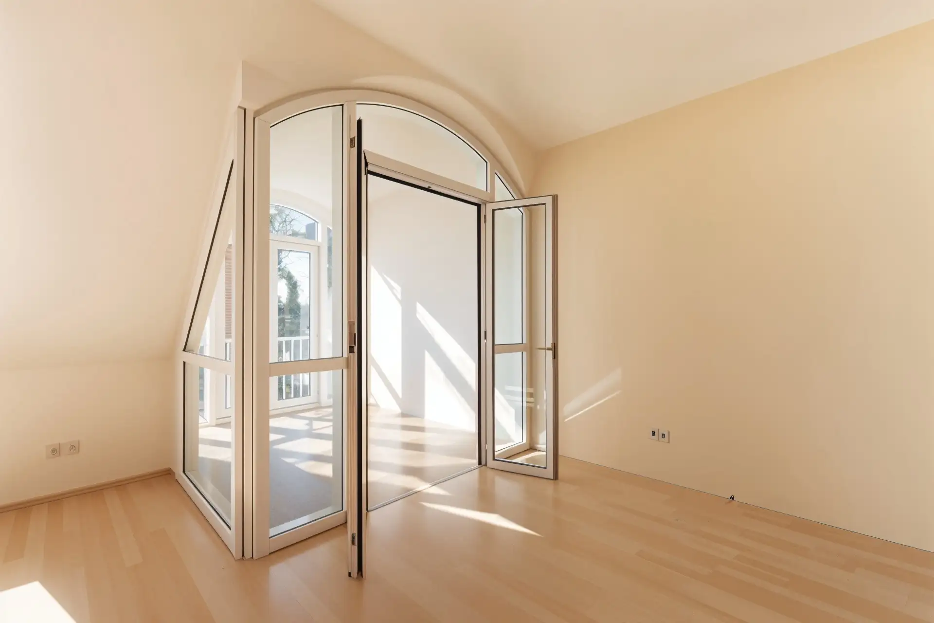 Heller Wintergarten mit Bogenverglasung und Holzboden in einer Wohnung in Haar
