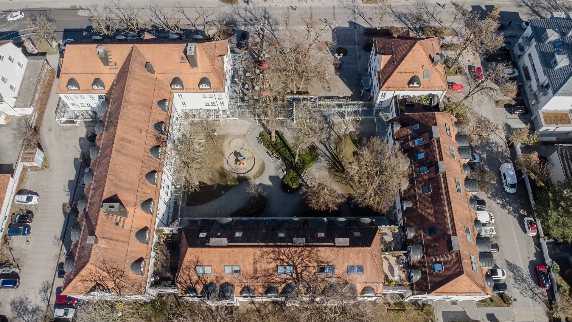 Luftaufnahme eines Wohnquartiers in Haar mit begrüntem Innenhof, Spielplatz und altem Baumbestand