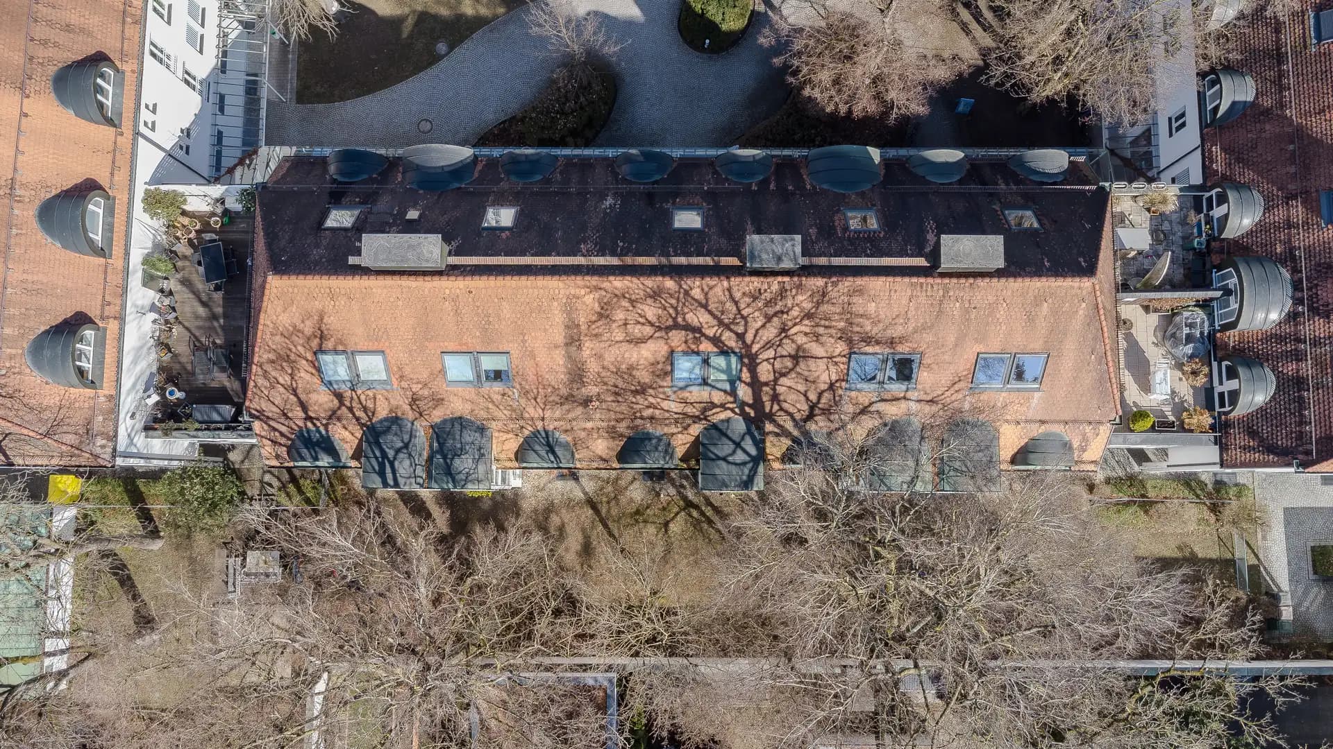 Dachlandschaft eines Wohnquartiers in Haar mit Gauben, Dachterrassen und altem Baumbestand