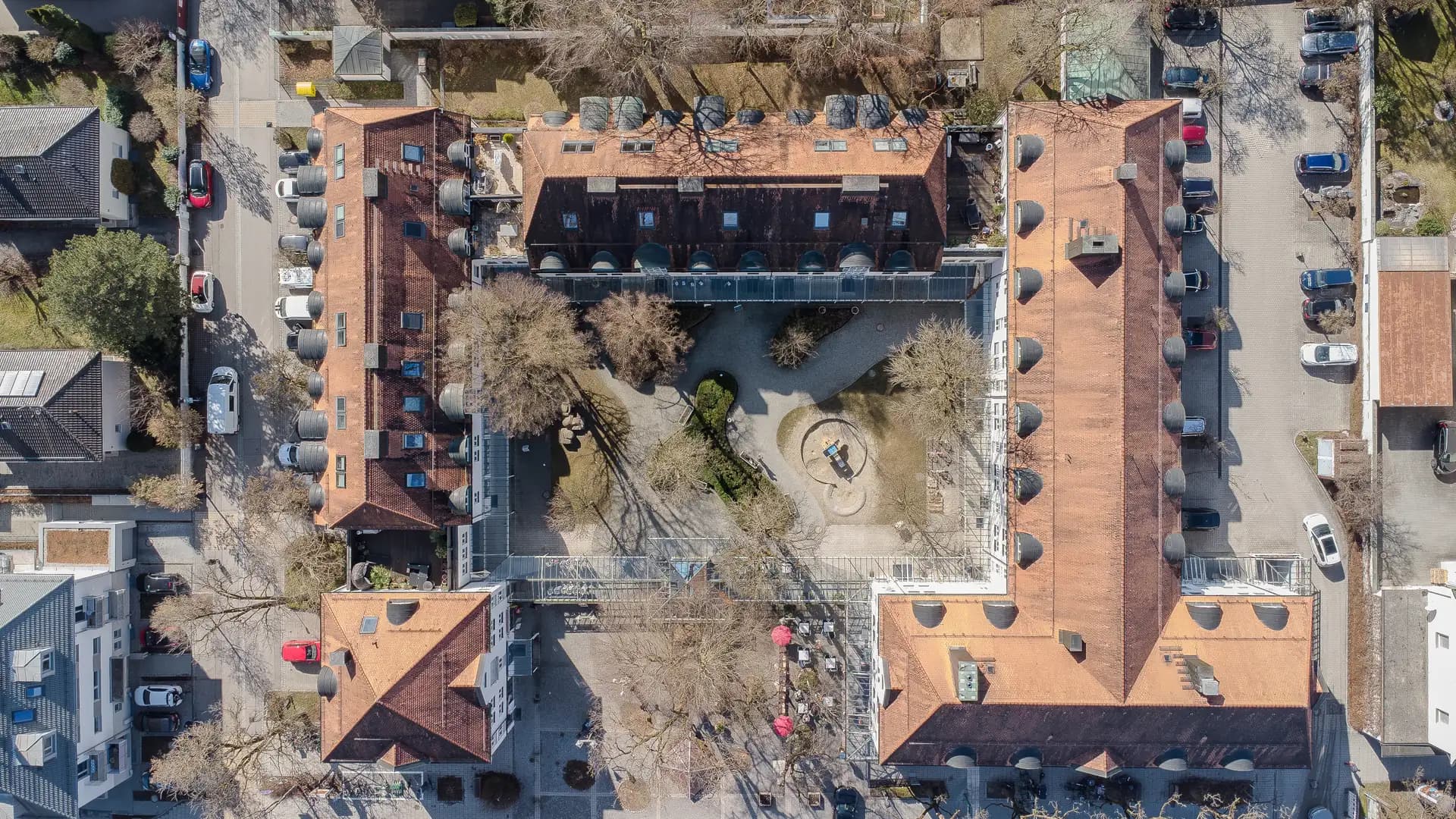 Senkrechte Luftaufnahme eines Wohnquartiers in Haar mit begrüntem Innenhof und Spielplatz