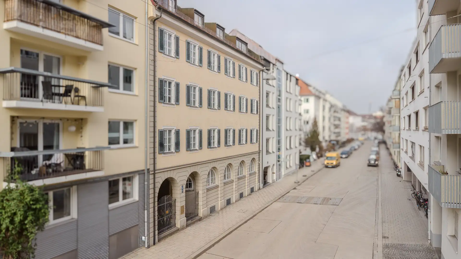 Gewachsenes Bestandsgebäude in einer ruhigen Münchner Straße – klassische Altbaufassade mit Fensterläden