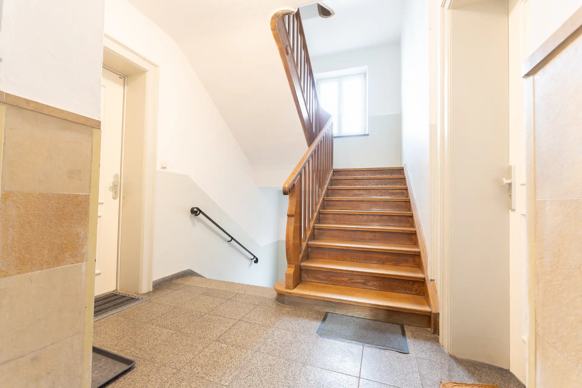 Holztreppenhaus eines Münchner Altbaus mit gepflegtem Gemeinschaftseigentum
